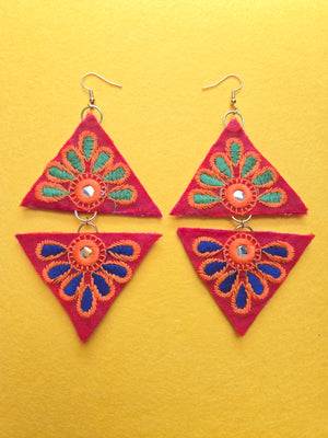 Blue & Green Petal Triangle Earrings Top and bottom mix and match green and blue embroidered fabric triangle shaped earrings arranged in a diamond shape. Earrings have a red background with embroidered green petals on the top triangle shape, and blue embroidered petals on the bottom triangle shape with hints of orange, along with a small mirrored center.  Earrings are 5 inches long and 2.5 inches wide with 18k gold plated ear wires.