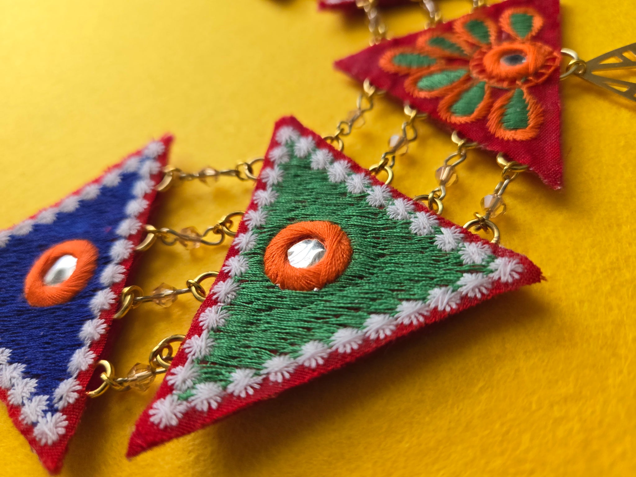 Closeup of two inch Colorful mix and match embroidered triangle shapes.